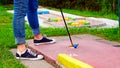 A woman playing miniature golf on a course Royalty Free Stock Photo