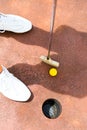 Woman playing miniature golf, holing in Royalty Free Stock Photo