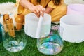 Woman playing music on crystal singing bowls