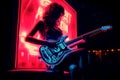 woman playing a neon electric guitar in a dark room