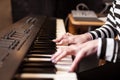 Woman playing piano record music on synthesizer using notes and laptop. Female hands musician pianist improves skills playing