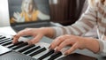 Woman playing piano during video call via laptop. Female hands musician pianist improves skills playing piano online