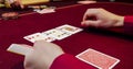 Woman playing poker on red table with chips and cards. Focus hand Royalty Free Stock Photo