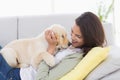 Woman playing with puppy while lying on sofa Royalty Free Stock Photo