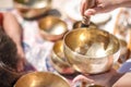 Woman playing a singing bowls also known as Tibetan Singing Bowls, Himalayan bowls. Making sound massage.