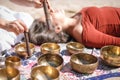 Woman playing a singing bowls also known as Tibetan Singing Bowls, Himalayan bowls. Making sound massage.