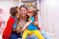 Happy family. A young woman plays with her children in superheroes Royalty Free Stock Photo