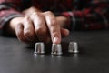 Woman playing thimblerig game with thimbles at black table, closeup Royalty Free Stock Photo