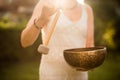 Woman playing Tibetan Singing Bowl with Mallet over Sunset Sky.Relaxing Music Therapy Royalty Free Stock Photo