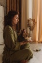 Woman playing on Tibetan singing bowl while sitting on yoga mat. Vintage tonned. Soft focus and noise effect