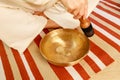 Woman playing on a tibetian singing bowl in cozy room meditating in a yoga Royalty Free Stock Photo