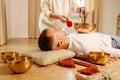 Woman playing on a tibetian singing bowl maling massage meditation for a man Royalty Free Stock Photo