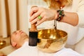 Woman playing on a tibetian singing bowl maling massage meditation for a man Royalty Free Stock Photo