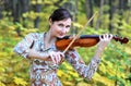 Woman playing the violin in the autumn park Royalty Free Stock Photo