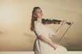 Woman playing violin on violin near beach Royalty Free Stock Photo