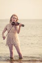 Woman playing violin on violin near beach Royalty Free Stock Photo