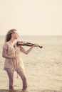 Woman playing violin on violin near beach Royalty Free Stock Photo