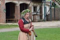 Woman playing wooden medieval flute in reenactment