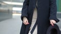 Woman plays with black hat waving wide-brimmed chapeau