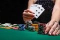 A woman plays in a casino. opening cards to raise bets. Against the background of chips. Poker victory Royalty Free Stock Photo