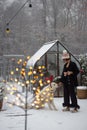 Woman plays with her dog on snowy backyard