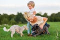 Woman plays with her son and two small dogs Royalty Free Stock Photo