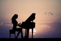 Woman plays the piano at sunset