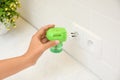 Woman plugging electric vaporizer with insect repellent liquid at home, closeup