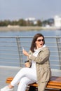 Woman plus size sit on the city embankment with mobile and coffee and hands and emotionally express outrage at someone