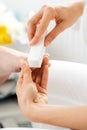 Woman podiatrist polishing nail of man during pedicure