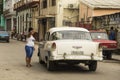 Woman pointing direction to vintage Chevy taxi Havana