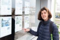 Woman pointing finger front of real estate agency