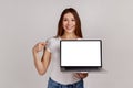 Woman pointing finger at laptop display, showing empty screen, bragging with internet advertisement. Royalty Free Stock Photo