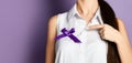 Woman pointing finger on purple ribbon to world epilepsy day. Alzheimer`s disease, pancreatic cancer