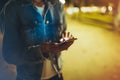 Woman pointing finger on screen smartphone on background illumination bokeh light in night atmospheric city, hipster using in hand Royalty Free Stock Photo