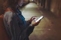 Woman pointing finger on screen smartphone on background illumination bokeh light in night atmospheric city, hipster using in hand Royalty Free Stock Photo