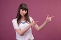 Woman pointing finger side. portrait on pinl background