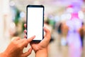 Woman pointing finger on smartphone with empty blank screen monitor on the background bokeh light in a luxury shopping store Royalty Free Stock Photo