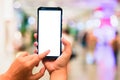Woman pointing finger on smartphone with empty blank screen monitor on the background bokeh light in a luxury shopping store