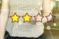 Woman pointing her finger at on a rating stars concept on a sunny day