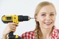 Woman pointing at her head with drill