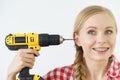 Woman pointing at her head with drill