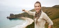 Woman pointing on something in front of ocean view landscape Royalty Free Stock Photo