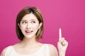 Woman pointing to somewhere, isolated on pink background Royalty Free Stock Photo