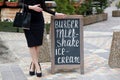 Woman points hand on the chalk stand, advertising street Royalty Free Stock Photo