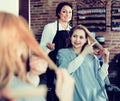 Woman points to master in hairdress salon right hair length for