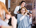 Woman points to master in hairdress salon right hair length for