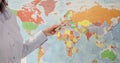 Woman points to world map in class