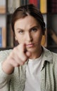 Woman points to you. Serious frowning woman looking at camera and points her finger in camera. Medium shot Royalty Free Stock Photo