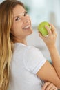 Woman poised to eat ripe green apple Royalty Free Stock Photo